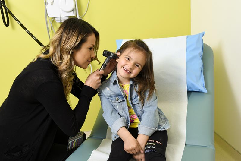 Smiling child getting ear checked